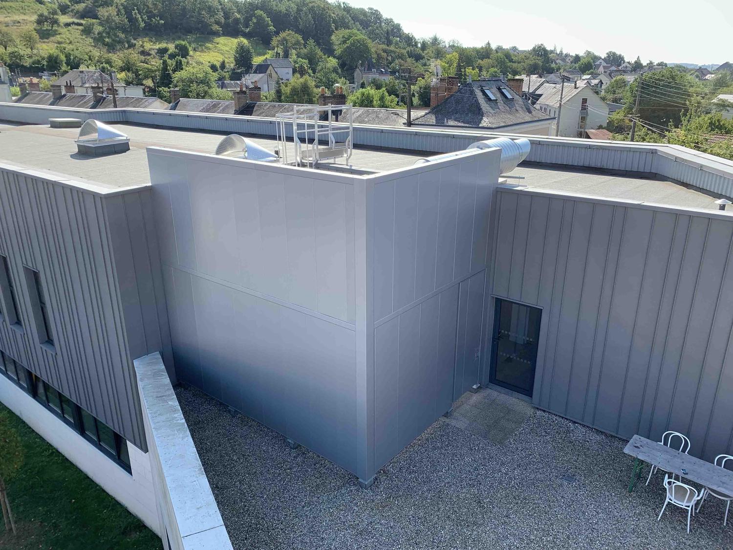 Équipement extérieur traité acoustiquement sur un site industriel.